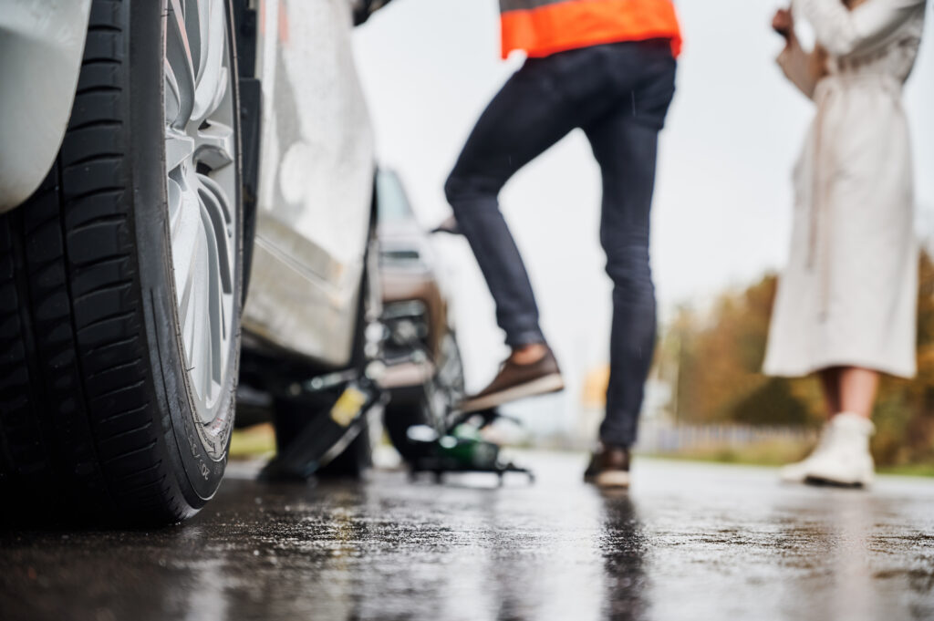 emergency auto mechanic repairing woman vehicle on the street.